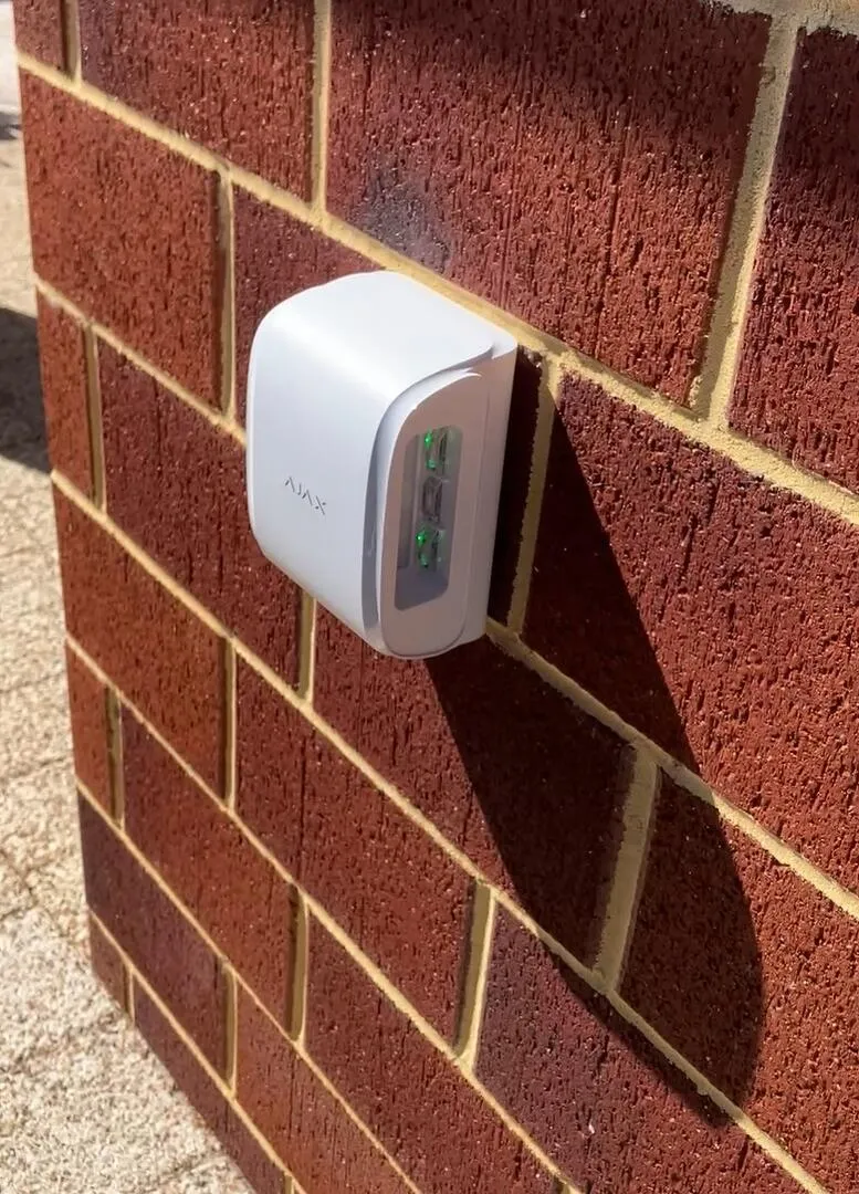 Ajax wireless outdoor device installed on a red brick wall at a Perth home