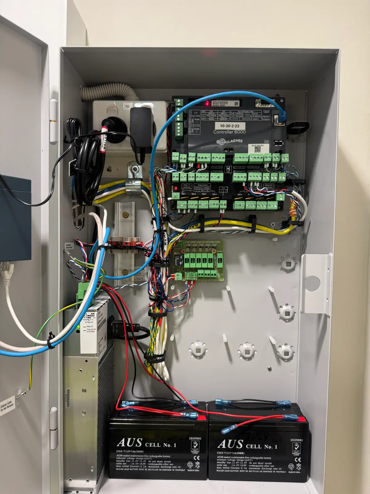 Commercial security controller enclosure open for a backup battery and board inspection at a Perth site