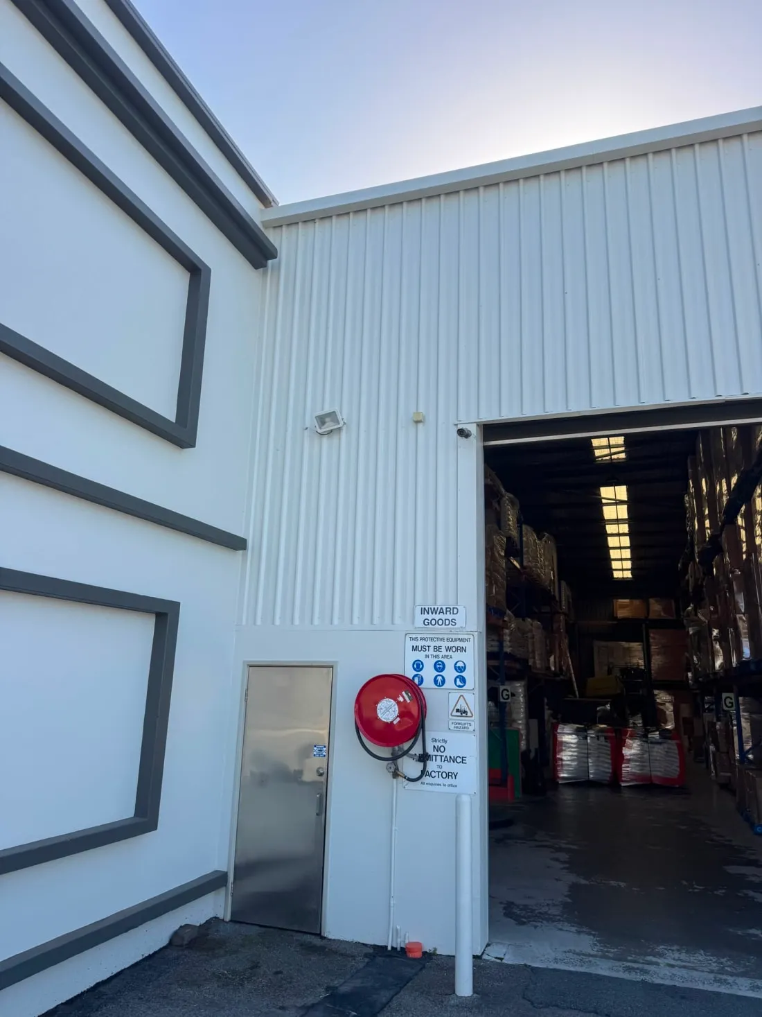 Warehouse inward goods entry with camera and floodlight above the roller door