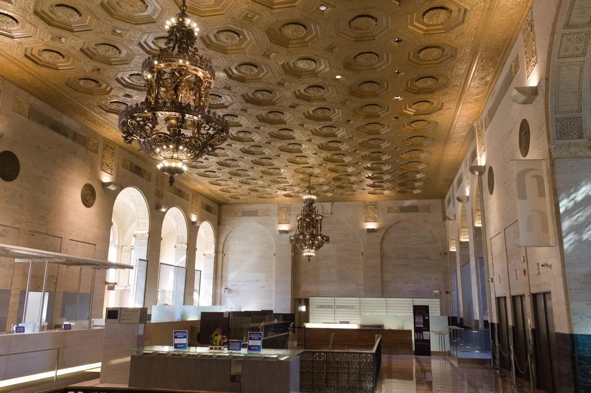 Banking chamber interior with teller counters and an ornate ceiling