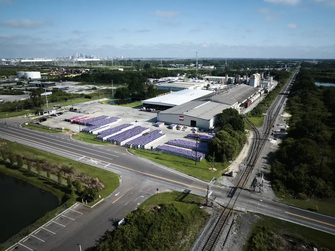 Aerial view of a manufacturing plant with production buildings and rail siding