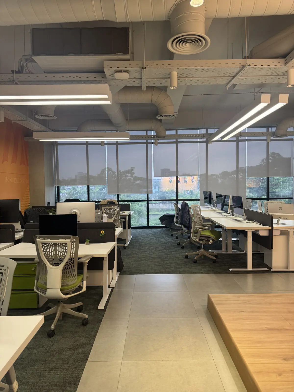 Modern open-plan office with desks, task chairs and full-height windows