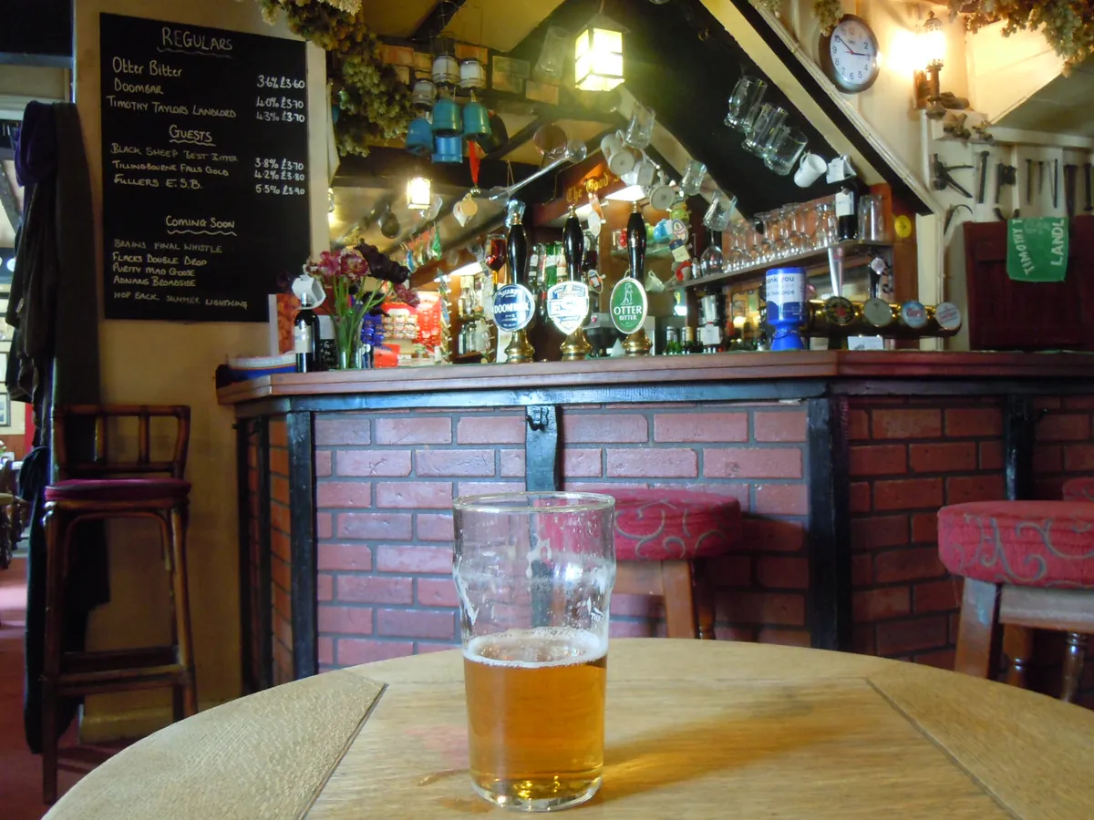 Bar interior of a pub with beer taps, counter and stools